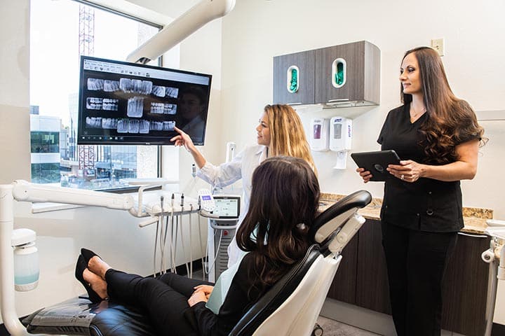 Dentist Dr. Turner showing patient x-rays at Aspen Dental Denver CO